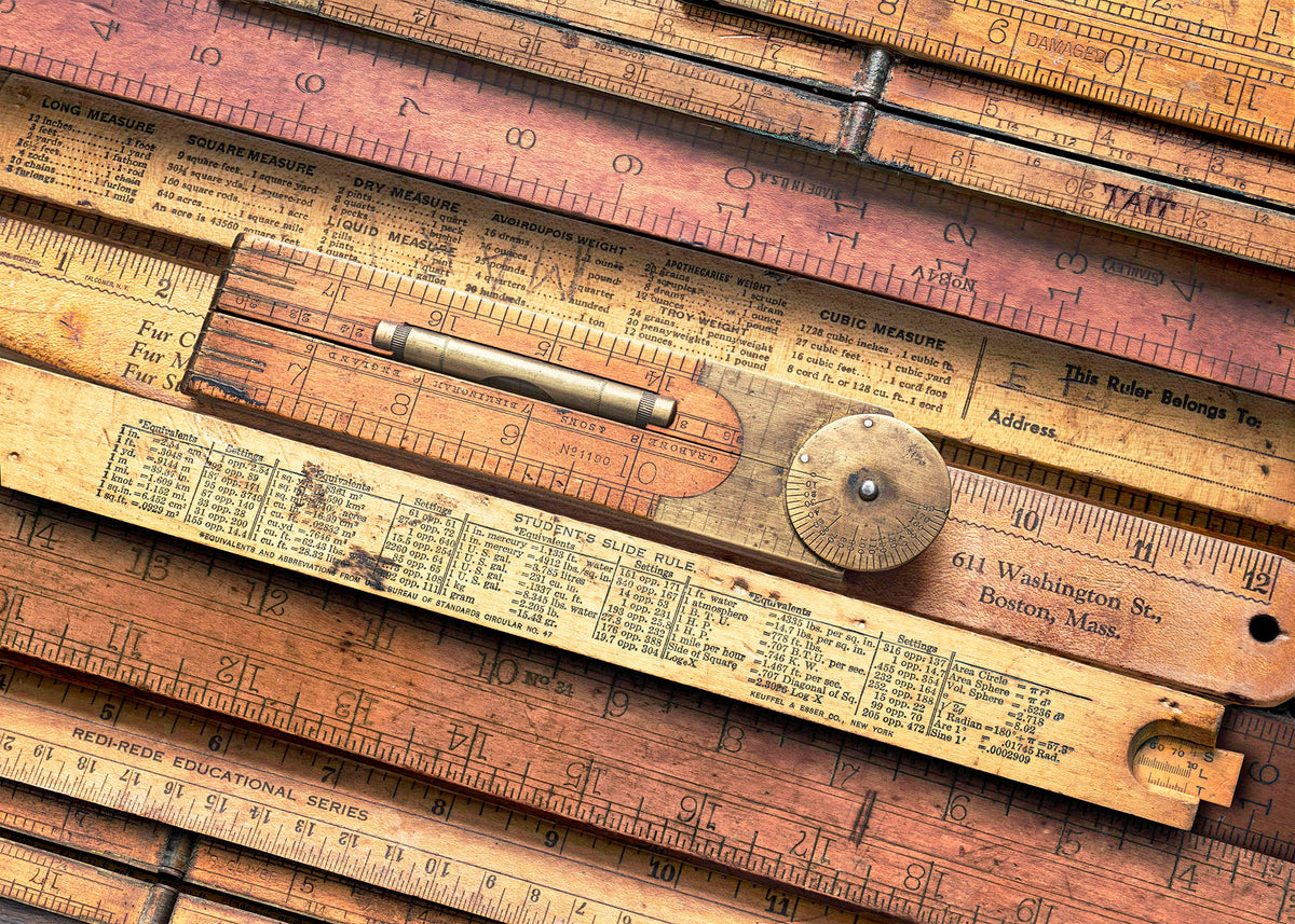 A detailed collage of vintage wooden folding rulers, featuring a student slide rule and a brass protractor dial.